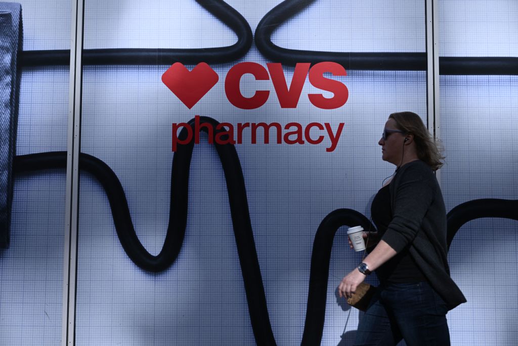 Photograph of a woman walking past a store front