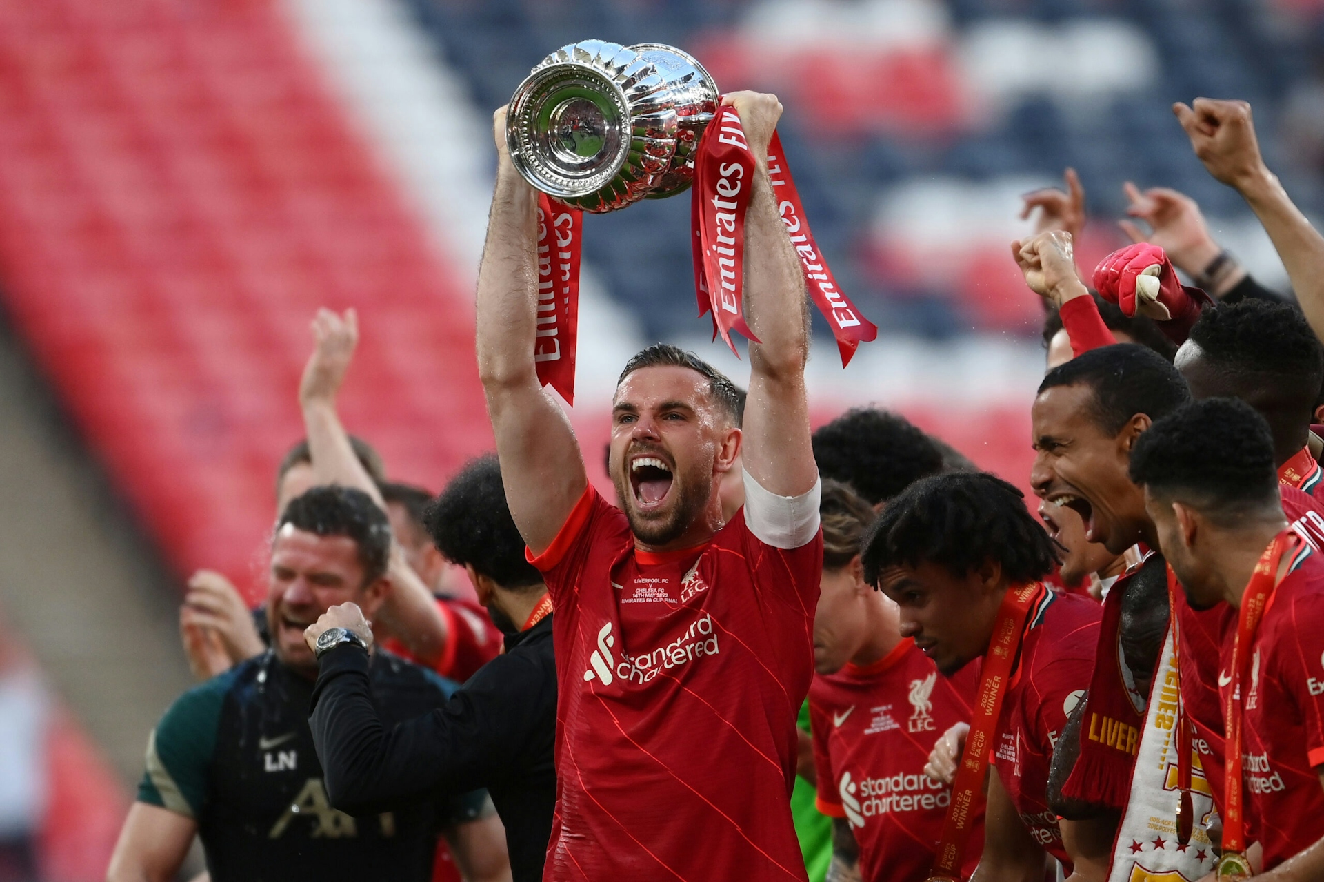 Photograph of Jordan Henderson of Liverpool lifting the Emirates FA Cup trophy at Wembley Stadium