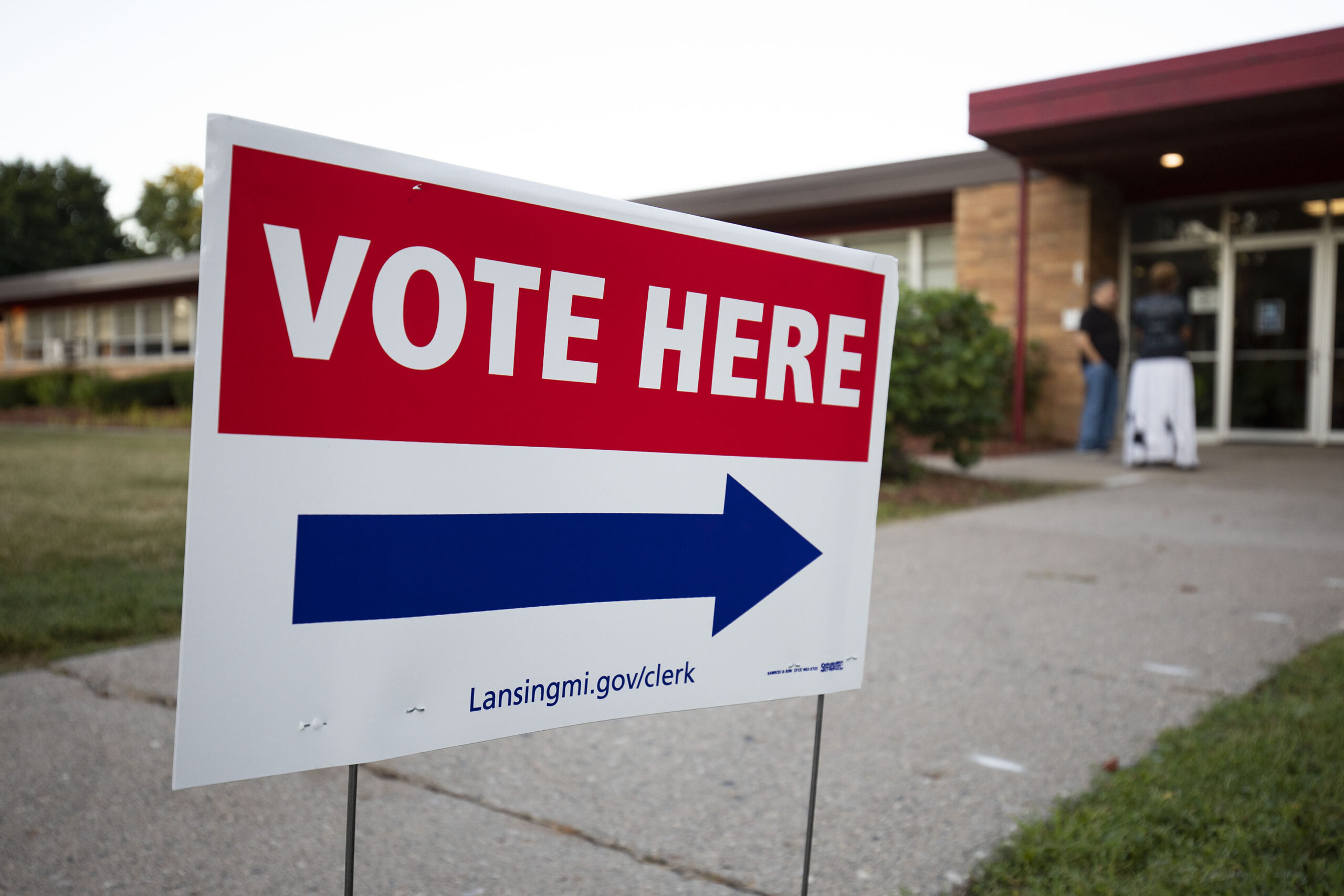 Photograph of sign reading "vote here"