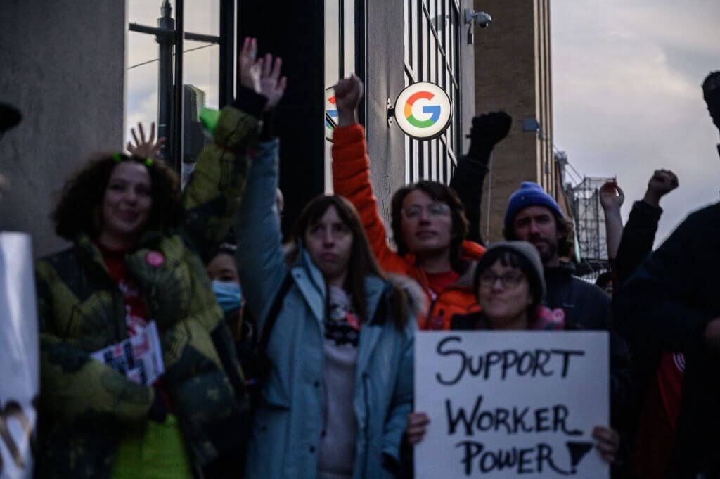 Photograph of workers rallying outside of Google offices in New York after recent layoffs with sign reading "Support Worker Power"