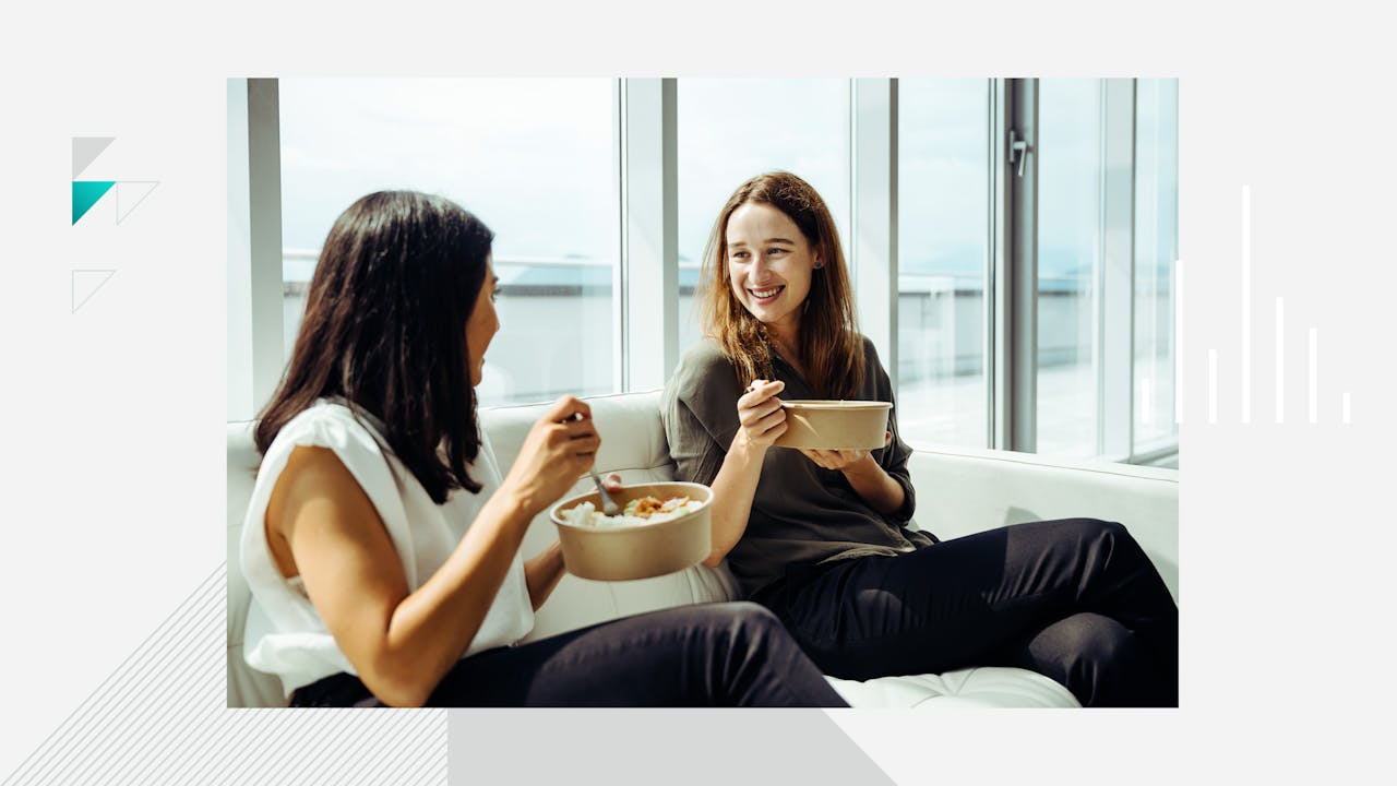 Image of two people eating in an office.