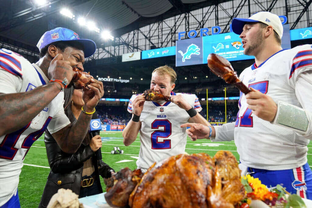 Photograph of Buffalo Bills players celebrating a win on Thanksgiving by eating Turkey